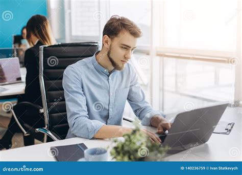 Portrait Of Young Man Sitting At His Desk In The Office Stock Image