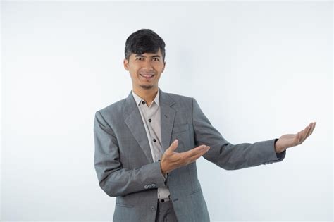 Un Hombre Con Un Traje Gris Se Para Con El Brazo Extendido Y Una Mano A