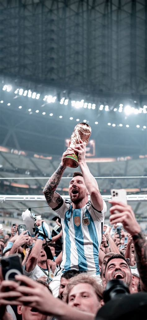 A Man Holding Up A Trophy In Front Of His Face While Surrounded By Fans