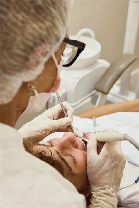 A Woman Getting Her Teeth Checked By A Dentist Photo Odontology Image On Unsplash