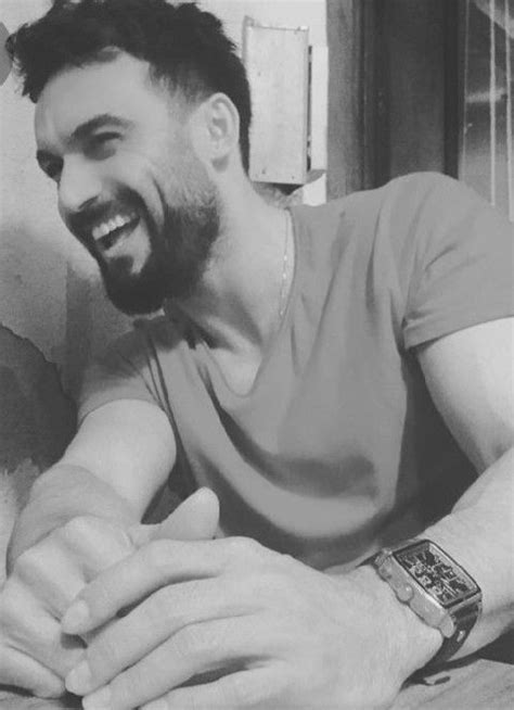 A Black And White Photo Of A Man Smiling With His Hands On The Table