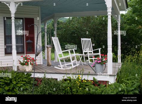 Two White Rocking Chairs On A Side Porch Of An Old Country House With