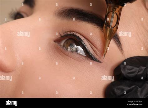 Young Woman Undergoing Procedure Of Permanent Eye Makeup In Tattoo