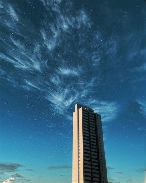 Un Edificio Alto Con Un Reloj Encima Foto Premium