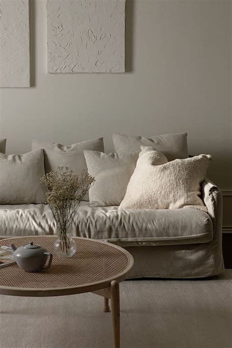 A Living Room Filled With Furniture And Pillows On Top Of A White