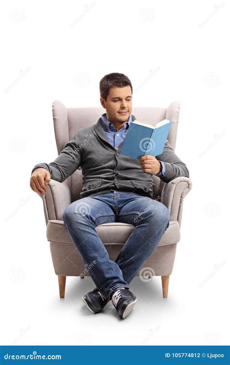 Young Guy Seated In An Armchair Reading A Book Stock Photo Image Of