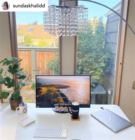 a desk with a computer, keyboard and mouse on it in front of a window