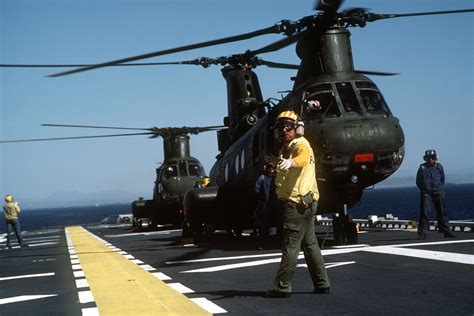 A Plane Director Stands By As A CH 46 Sea Knight Helicopter Prepares