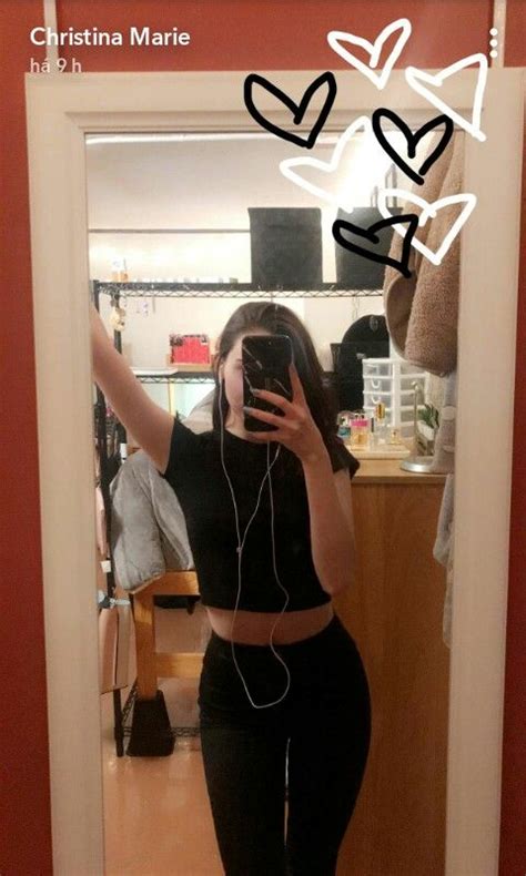 A Woman Taking A Selfie In Front Of A Mirror With Headphones Attached