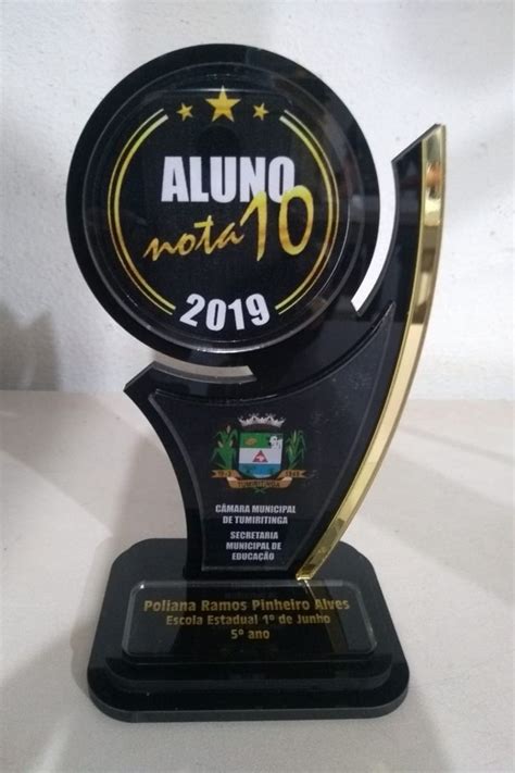 An Award Is Displayed On A White Surface With A Black And Gold Trophy