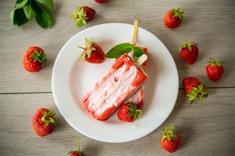 Premium Photo Cooked Homemade Strawberry Ice Cream On A Stick In A Plate With Strawberries