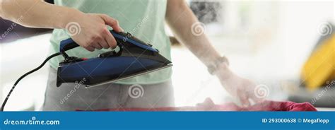 Housewife Irons Red Blouse With Hot Steam Appliance At Home Stock Photo