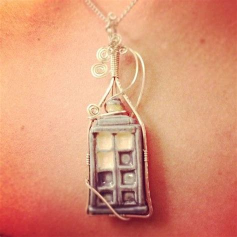 A Woman S Back With A Necklace That Has A Phone Booth Attached To It