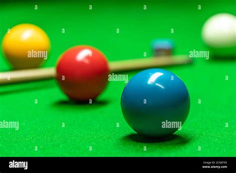 A cue and snooker balls of various colors are placed on the snooker ...