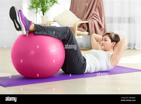 Mature Woman Training With Fitball At Home Weight Loss Concept Stock