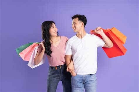 Premium Photo Image Of Asian Couple Holding Shopping Bags On Purple