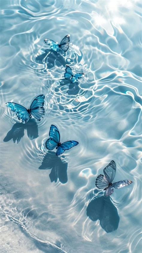 Three Blue Butterflies Floating In Water With Ripples On The Bottom And