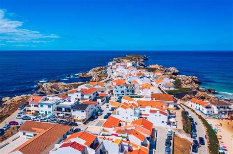 An Aerial View Of A Small Town By The Ocean With Orange Roofed