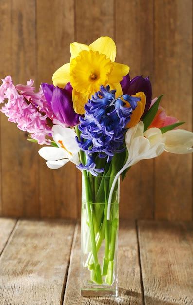 Premium Photo Beautiful Spring Flowers In Glass Vase On Wooden Background