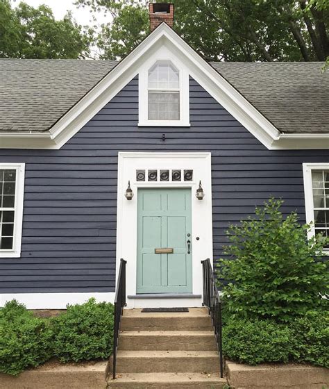 A Blue And White House With Stairs Leading Up To The Front Door