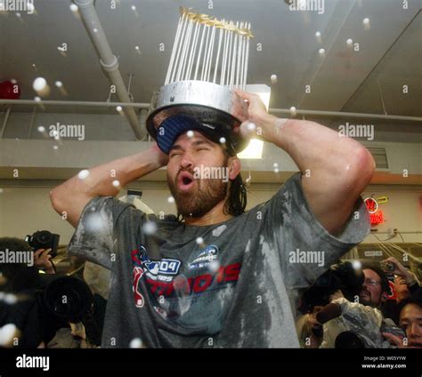 Boston Red Soxs Johnny Damon Holds The World Championship Trophy Over