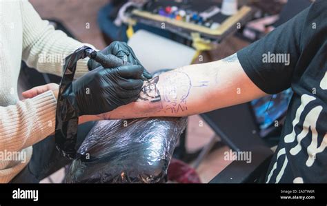 Tatoueur Professionnel Fait Un Tatouage Sur La Main D Un Jeune Homme