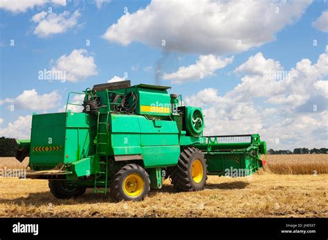 Combine Machine Is Harvesting Oats On Farm Field Combine Harvester