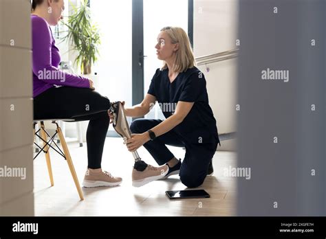 Physical Therapist Fitting Prosthetic Leg For Patient In Rehabilitation Clinic Healthcare