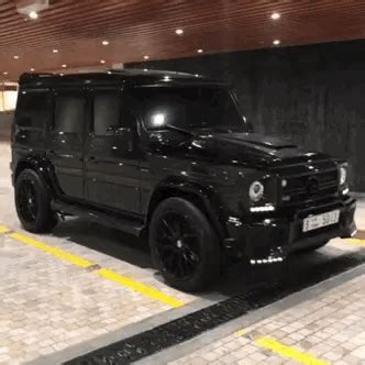 A Black Mercedes G Class Is Parked In A Parking Garage With Yellow