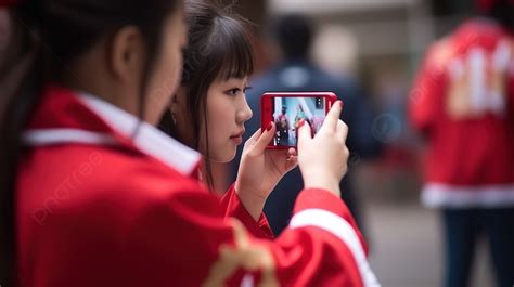 赤い制服を着て携帯電話を持っている 2 人の若い女の子イラスト スマホを見ているチアリーダー Hd写真撮影写真 携帯電話背景画像素材無料