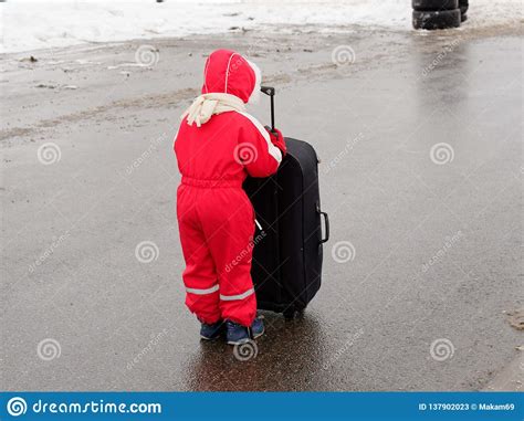 Un Petit Enfant Se Tient Sur La Route Avec Une Grande Valise Image