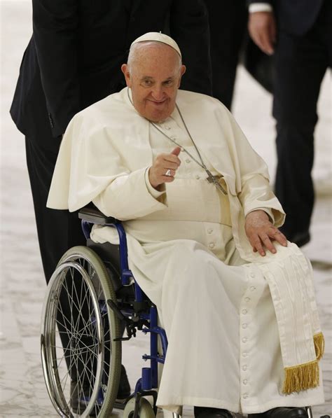 Pope Francis gives a thumbs up as he rides in a wheelchair during his ...