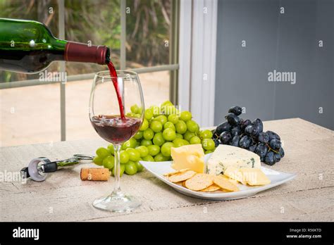 Glass Of Red Wine With Wine Bottle Cheese Crackers Ham Almonds And