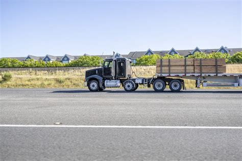 Black Big Rig Semi Truck Tractor With Extended Cab Transporting Lumber