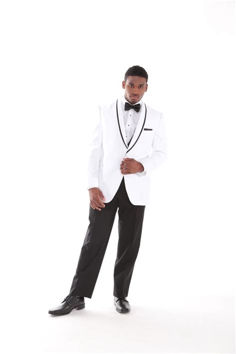 A Man In A Tuxedo Poses For The Camera With His Hands On His Hips