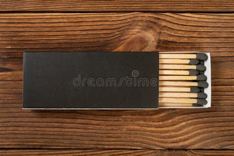 Black Color Matchbox With Black Match Sticks On A Wood Table Stock