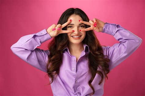 Happy Smiling Woman Showing Victory Sign Against Pink Background Stock