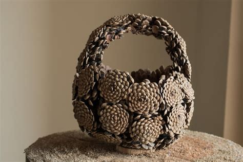 Premium Photo Hand Basket Made Of Pine Cones Placed On A Log