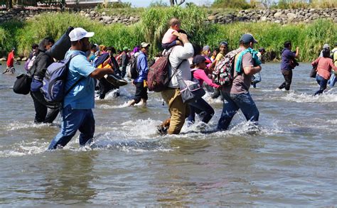 Caravana de migrantes ingresa a la fuerza a México por el río Suchiate