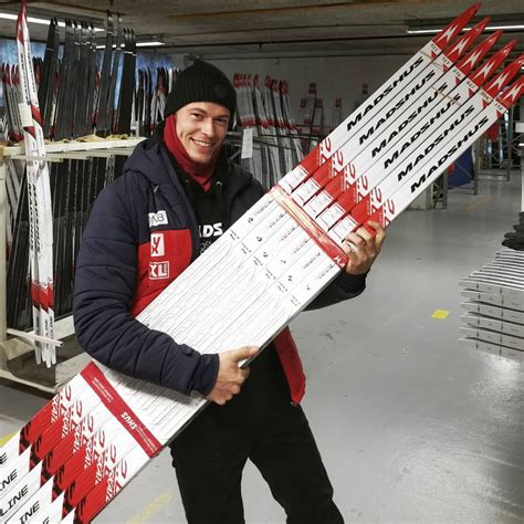 A Man Holding Up A Large Snowboard In A Warehouse