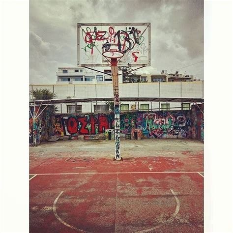 An Old Basketball Court With Graffiti All Over It And A Basket In The