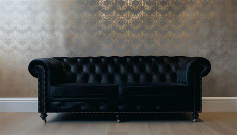 Premium Photo | A black leather sofa with a gold floral wallpaper on ...