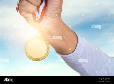 Man Raising Hand And Holding Gold Medal Concept Of Ambition