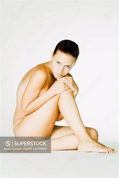 Nude Woman Sitting Resting Head On Knee Looking At Camera SuperStock