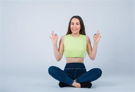 Une Fille Souriante Montre Des Gestes Corrects En S Asseyant Sur Le Sol