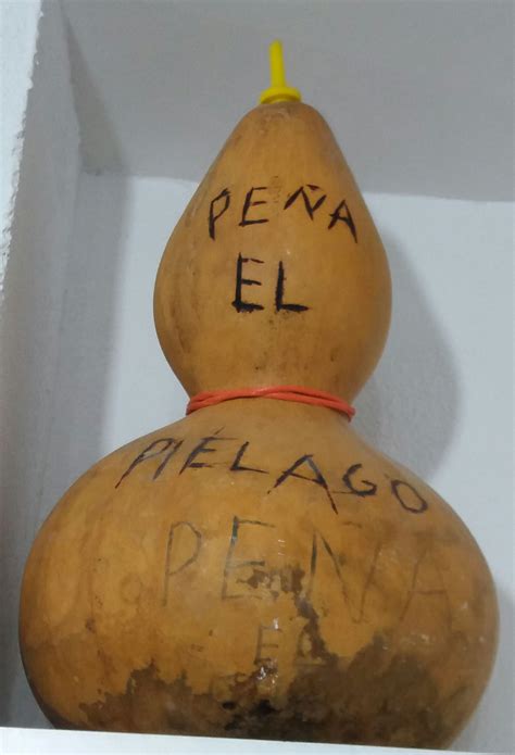 A Wooden Object With Writing On It Sitting In A White Box Next To A Wall