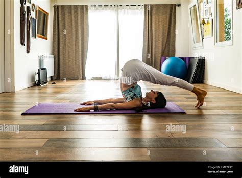 Side View Of A Woman Practicing Yoga Doing Plow Pose Halasana Pose