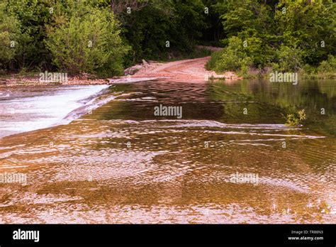 The Water Of Spring Creek Flowing Over The Concrete Slab Bridge Located