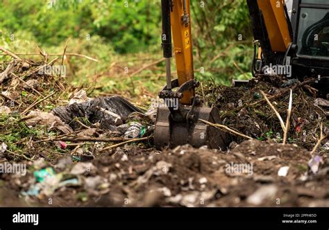 Backhoe digging soil at construction site. Bucket of backhoe digging soil. Clearing and grubbing ...