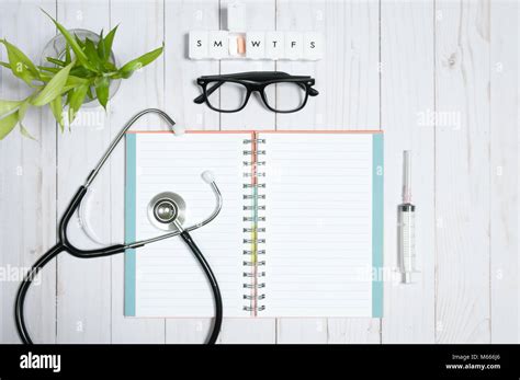 Workplace Of Doctor Stethoscope Notebook Medical Items And Pills On